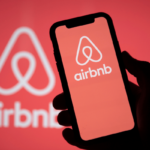 An Airbnb Logo on mobile and background